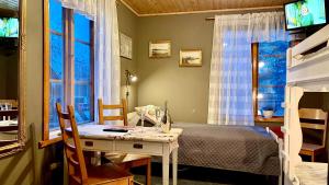 a bedroom with a bed and a desk and a table at Prinsgården B&B rum stugor in Mora