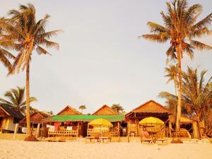 a resort on the beach with two palm trees at Solmar Beach Camp in San Vicente