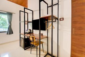 a room with a table and a desk in a room at Hotel O Citrus Resort in Āmbavna