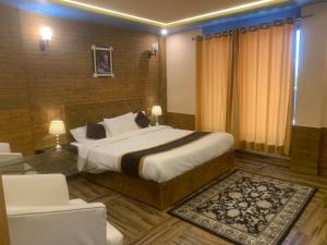 a hotel room with a bed and a chair in it at Green Executive Hotel in Nathia Gali