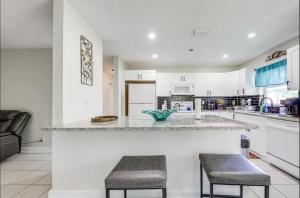 a kitchen with a counter and two stools in it at Downtown Lake Worth Retreat in Lake Worth Corridor