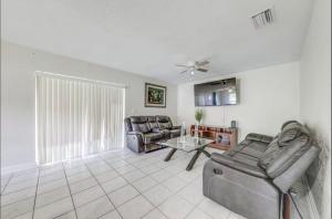 a living room with two chairs and a table at Downtown Lake Worth Retreat in Lake Worth Corridor