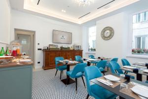 a dining room with tables and blue chairs at Hotel Odeon Napoli in Naples