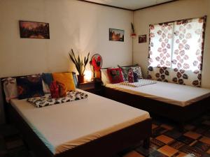 two beds sitting in a room with a window at Solmar Beach Camp in San Vicente