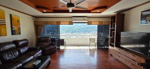 a living room with a couch and a flat screen tv at PATONG TOWER SPACIOUS FAMILIES APARTMENT with 2 BATHROOMS 3&4 BEDROOMS Pta in Patong Beach