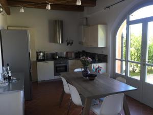 kuchnia z drewnianym stołem i białymi krzesłami w obiekcie La Famulenta garden apartment w mieście Grazzano Badoglio
