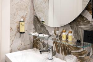 a bathroom with a sink and a mirror and a sink at Hotel Odeon Napoli in Naples +57 photos