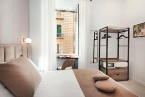 a bedroom with a bed and a desk and a window at Hotel Odeon Napoli in Naples