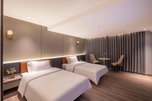 a hotel room with two beds and a table at Guangzhou Xingdu International Hotel in Guangzhou