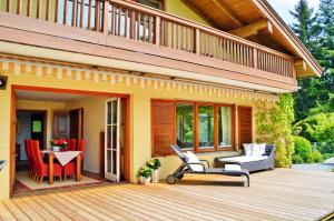 eine Terrasse mit Stühlen und einem Tisch auf einem Haus in der Unterkunft Chiemsee Landhaus in Breitbrunn am Chiemsee