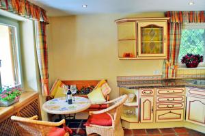 eine Küche mit einem Tisch, Stühlen und einer Theke in der Unterkunft Chiemsee Landhaus in Breitbrunn am Chiemsee