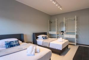 a bedroom with two beds and two mirrors at Casa Viola in Reggio di Calabria