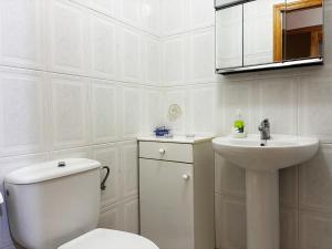 a white bathroom with a toilet and a sink at Casa De La Virginia in Valdealgorfa +17 photos