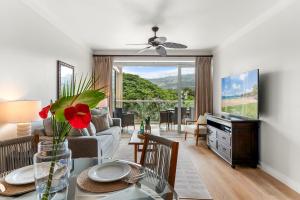 a living room with a couch and a table with a vase of flowers at Maui Luxury Mountain-View Villa at Honua Kai in Lahaina