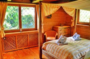 ein Schlafzimmer mit einem Bett in einem Blockhaus in der Unterkunft Chiemsee Landhaus in Breitbrunn am Chiemsee