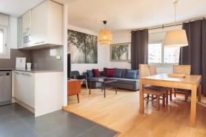 Una cocina y una sala de estar con una mesa y un sofá. en Mar Bella Beach Apartments, en Barcelona