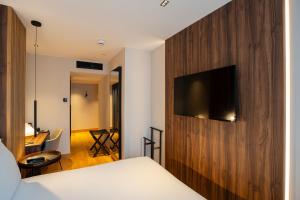 een slaapkamer met een houten muur en een tv. bij Zenit Borrell in Barcelona