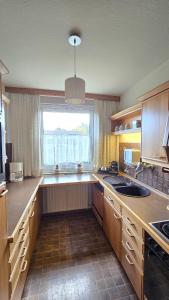 a large kitchen with a window and a sink at Urban Comfort Apartment - Nähe Uni & Zentrum in Bielefeld +7 photos