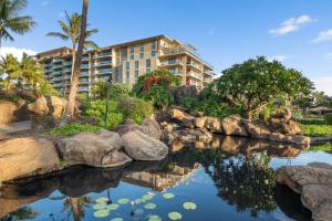 a resort with a pond in front of a building at Maui Luxury Mountain-View Villa at Honua Kai in Lahaina