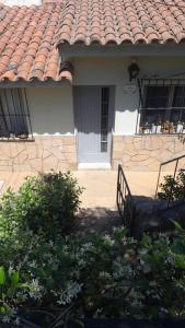 ein Haus mit einem gefliesten Dach und einer Veranda in der Unterkunft Casa con jardín y vista al cerro en Portezuelo Salta in Salta