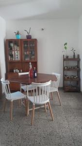 einem Esstisch mit zwei weißen Stühlen in der Unterkunft Casa con jardín y vista al cerro en Portezuelo Salta in Salta