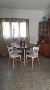 ein Esstisch und zwei weiße Stühle und ein Tisch und Stühle in der Unterkunft Casa con jardín y vista al cerro en Portezuelo Salta in Salta