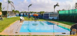 a couple of people standing around a swimming pool at منتزه السلامة Parc ASSALAMA in Kenitra