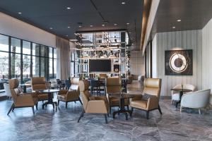 a lobby with tables and chairs and a television at AC Hotel by Marriott Las Vegas Symphony Park in Las Vegas