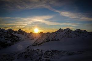 un coucher de soleil sur une chaîne de montagnes enneigée dans l'établissement Haus Bergheim, à Sankt Leonhard im Pitztal