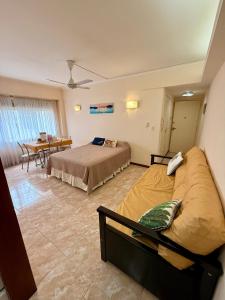 a bedroom with two beds and a table in it at Depto sobre Peatonal San Martin, Mar del Plata in Mar del Plata