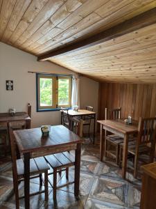 a room with wooden tables and chairs and a window at Astral de Minas in Tiradentes