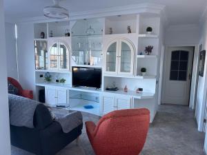een woonkamer met een tv op een witte plank bij Crisol Apartamento in Puerto de la Madera