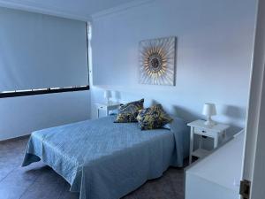 een blauwe slaapkamer met een bed met 2 kussens bij Crisol Apartamento in Puerto de la Madera
