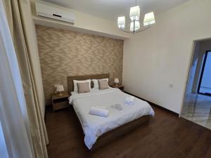 エレバンにあるYour Yerevan Homeのベッドとタオル2枚のある寝室