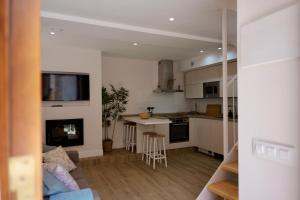a kitchen and living room with a couch and a fireplace at El sueñu de Chari in Llanes