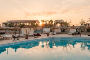 a pool at a resort with tables and chairs at we agafay in El Karia