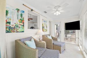a living room with two chairs and a flat screen tv at Anna Cabana Bungalow #1 in Holmes Beach