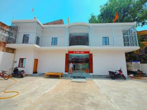 un hombre parado frente a un edificio blanco en Hotel Shri Ram Anadam Inn, en Masodha