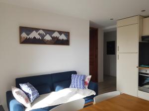 a living room with a blue couch and a table at Lis Martagon in Font-Romeu