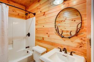 a bathroom with a wooden wall with a sink and a mirror at Rhododendron Rendezvous in Blowing Rock +47 photos