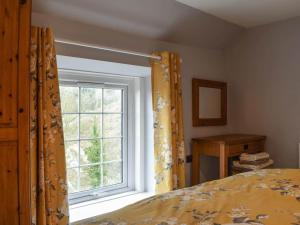 a bedroom with a bed and a window at Stone Cottage in Wirksworth near Peak District in Wirksworth