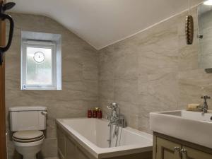 a bathroom with a tub and a toilet and a sink at Stone Cottage in Wirksworth near Peak District in Wirksworth