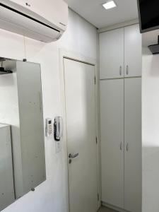 ein Raum mit weißen Schränken und einer Tür in der Unterkunft Studio Santorini Vila Mariana in São Paulo