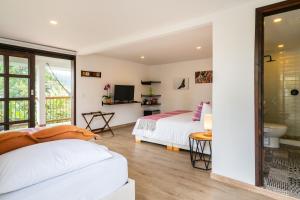 two beds in a room with a bathroom at Terasu Hotel Boutique Salento in Salento