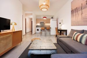 una sala de estar con un sofá y una mesa en Portal Del Angel Barcelona Apartment, en Barcelona