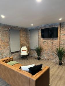 a living room with a brown couch and a brick wall at Short North Convention King Bed Free Parking! in Columbus