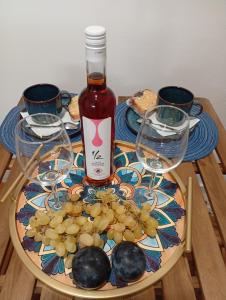 a table with a bottle of wine and some glasses at Ενοικιαζόμενα Δωμάτια "ΜΕΡΣΙΝΗ" in Karistos