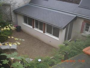 a small white house with a black roof at Gîte Mélany in Chargé