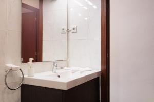 un baño con lavabo y espejo en Portal Del Angel Barcelona Apartment, en Barcelona 8 fotos más