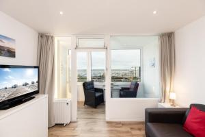 a living room with a couch and a tv at Marina Wendtorf Leuchtturmblick in Wendtorf